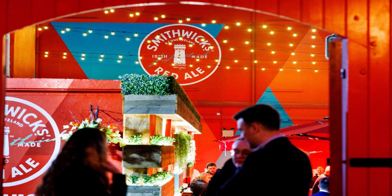 red walls with bright white faity lights. Two people sitting at a table