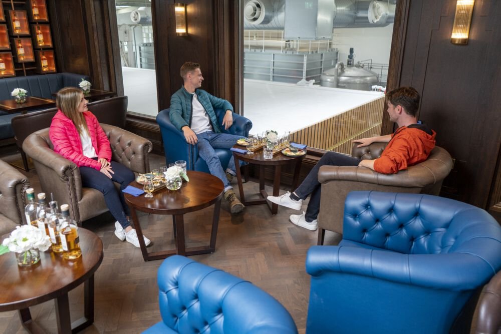 three people sitting down looking through glass 